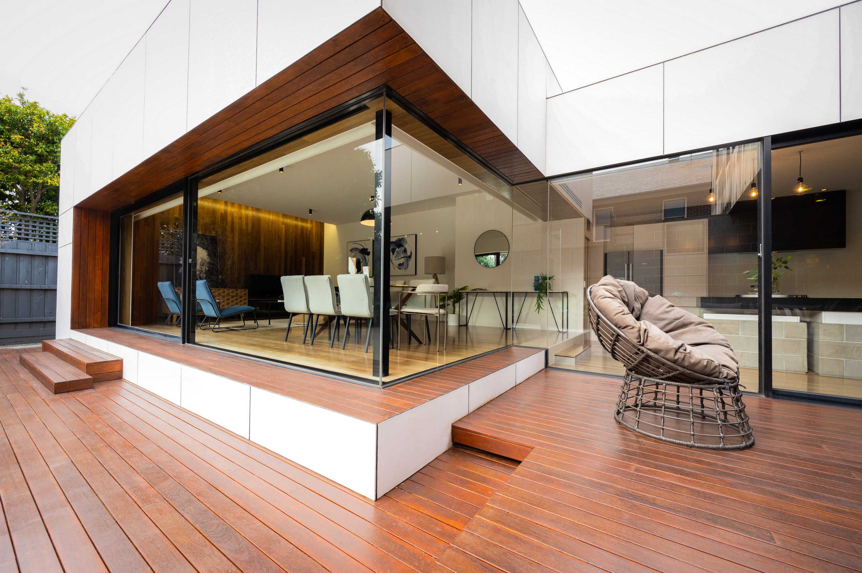 Residential open-plan rear extension — XN Series 38 sliding doors in black powder-coat opening onto timber deck